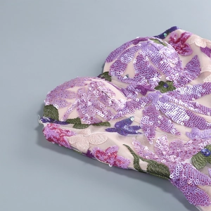 Detailed view of floral butterfly embroidery with colorful sequins on mesh fabric