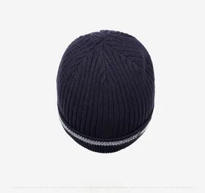Top view of navy blue ribbed knit beanie with grey striped accents and crown detail