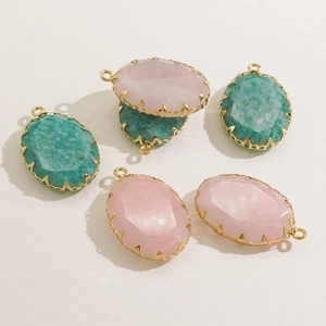 Detailed view of faceted oval natural stone pendants with gold plated stainless steel edges
