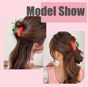 Detailed view of a red strawberry acrylic hair claw clip worn on a sweet ponytail hairstyle