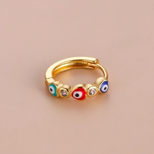 Detailed view of gold evil eye ring with blue and red enamel and clear gemstones
