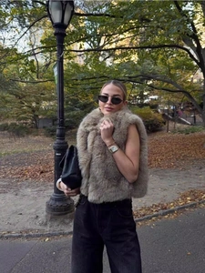 Outdoor streetstyle opname van een dikke bruine faux fur vest in een herfstige parkomgeving