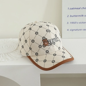 Détail de la casquette en velours beige avec broderie d'ours et motifs de lettres N