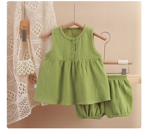 Close-up of green gauze cotton baby girl pajamas set with sleeveless top and bloomers