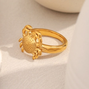 Macro shot of gold crab ring with detailed embossed texture and 18K plated finish