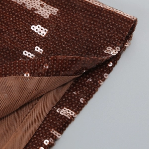 Detailed view of bronze sequin fabric texture with matching mesh lining for party dress