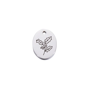 Macro shot of mirror-finish oval stainless steel holly flower pendant with fine engraving
