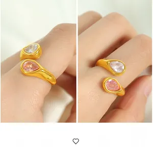 Detailed macro view of gold-plated open ring with pink and clear pear-cut stones
