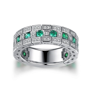 Retro silver brick pattern wide band ring with green and clear gemstones on white background