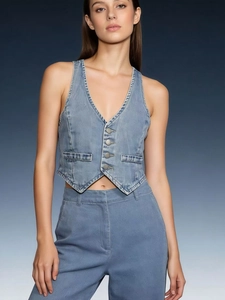 Detail of blue denim vest featuring V-neck design and metallic button closures