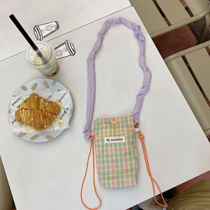Detail of colorful checkered fabric mobile phone bag with purple pleated shoulder strap