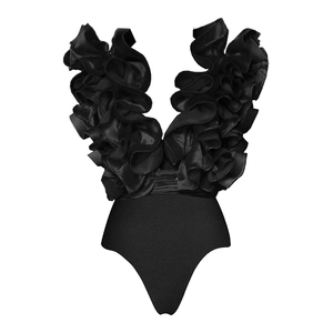 Close-up detail of oversized ruffled shoulders and deep V-neckline on a black swimsuit