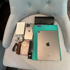 Lightweight green nylon organizer bag shown with daily essentials on a chair