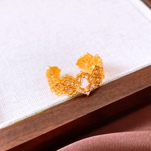 Macro view of vintage gold ring with filigree lace details and marquise-cut crystal center