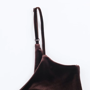 Detail of adjustable spaghetti straps on luxury dark brown velvet dress with smooth texture