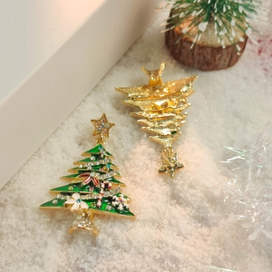Close-up of festive Christmas tree earrings with green enamel and colorful rhinestones