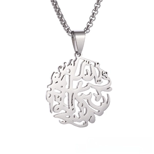 Detail of silver stainless steel pendant with intricate Arabic calligraphy cutout design