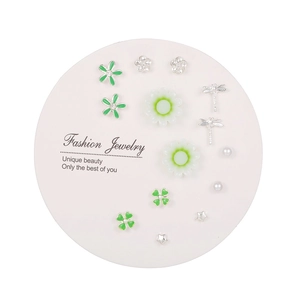 7-day variety earring set with silver flower, dragonfly, and clover studs on a white card