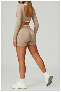 Detail of camel seamless yoga set featuring cross back crop top and ribbed booty shorts