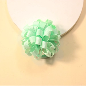 Detailed close-up of mint green curly grosgrain ribbon hair tie for kids accessories