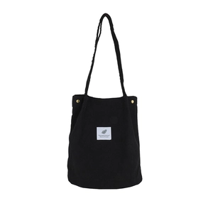Black corduroy tote bag with vintage metal snaps and nature leaf square label