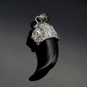 Detailed view of resin wolf tooth pendant with silver lion head stainless steel cap