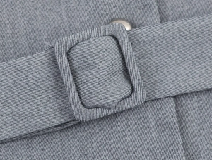 Detailed macro view of gray crepe fabric texture and matching square belt buckle detail