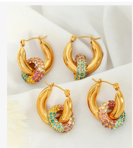 Detail of gold titanium steel hoop earrings with pavé colorful crystal rings on silk