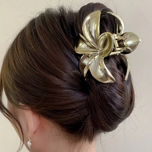 Vista dettagliata del fermaglio a fiore dorato grande su un'acconciatura a chignon posteriore
