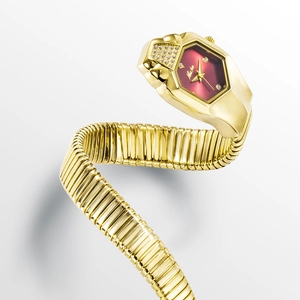 Detail of golden snake-shaped watch with red dial and crystal embellishments