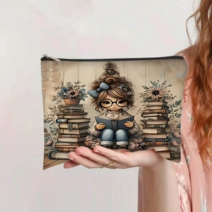 Detail of printed canvas zipper pouch showing a girl reading illustration held by a person