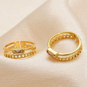 Double-layered gold hollow ring with square zircon stone on luxury silk fabric
