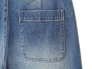 Detail of light blue washed denim jeans showing back pocket design and double stitching