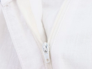 Vue macro de la texture du tissu blanc et du détail du zip sur l'ensemble décontracté