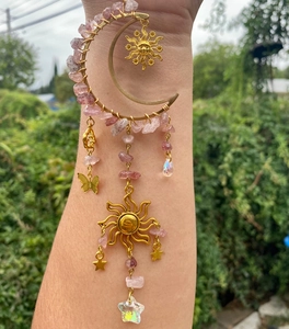 Detail of moon suncatcher with pink crystals, brass charms and star prism pendant
