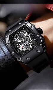 Macro detail of tonneau-shaped black skeleton watch featuring luminous dial and rubber strap