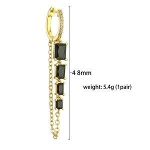 Detail view of gold earrings with black rectangular zirconia and long chain tassels