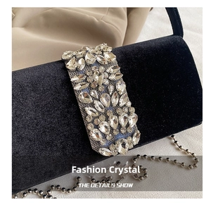 Detailed shot of black velvet evening bag featuring sparkling rhinestone panel and silver chain