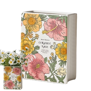 Detail of book-shaped ceramic vase with floral pattern and inspirational quote