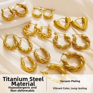 Close-up of gold titanium steel hoop earrings with woven and twisted textures