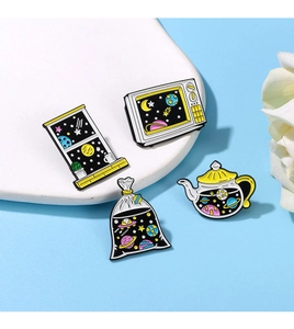 Detailed view of four space-themed enamel pins featuring star and planet motifs