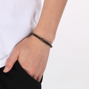 Détail d'un bracelet chaîne minimaliste en acier inoxydable noir avec fermoir cylindrique