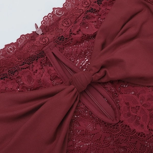 Detail of red lace dress featuring satin bow and concealed zipper closure