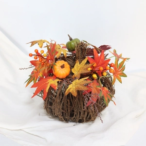 Autumn candle ring with mini pumpkins, maple leaves, and berries on woven dry branches