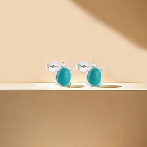 Detailed macro of S925 silver stud earrings featuring turquoise flower and moon design