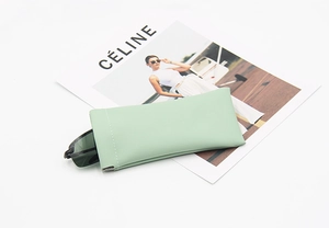 Detail of mint green faux leather sunglasses pouch with white stitching and squeeze closure