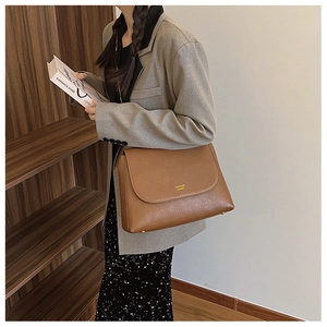 Detail of brown PU leather chain shoulder bag featuring metal buckle and brand logo