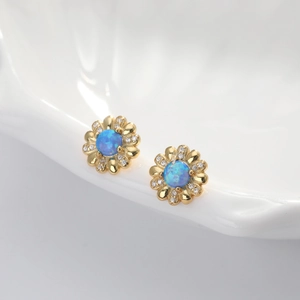 Makro-Detail von Blumen-Ohrsteckern in Gold mit blauem Opal und Mikropavé-Zirkoniasteinen