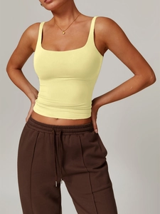 Detail view of a pale yellow Y2K slim-fit yoga tank top on a model with grey background