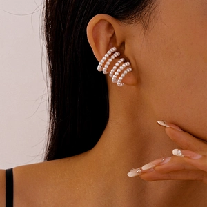 Detailed close-up of multi-layer faux pearl ear cuff showing polished white beads and C-shape